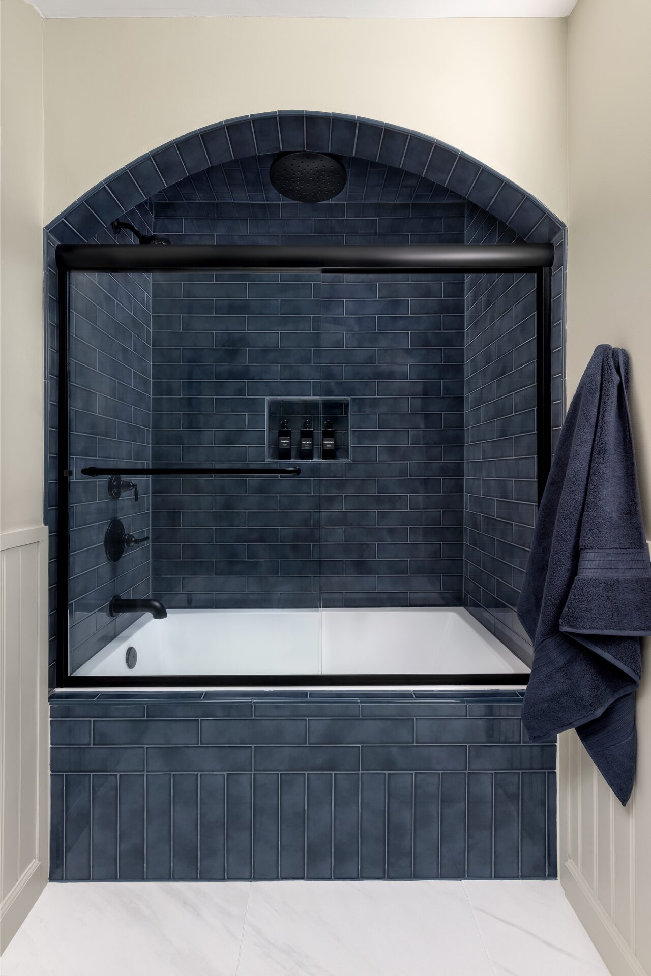 Willowgate arched freestanding tub surround with book-matched stone cladding